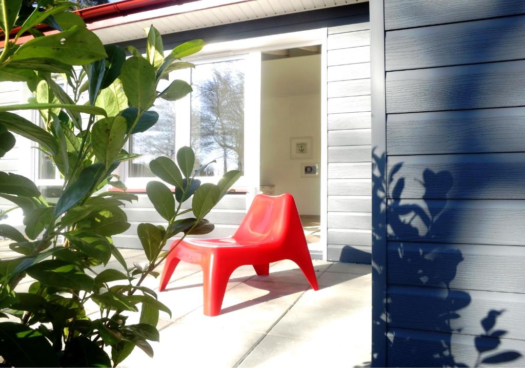 a red chair in a room with a plant at Babie Lato in Łazy