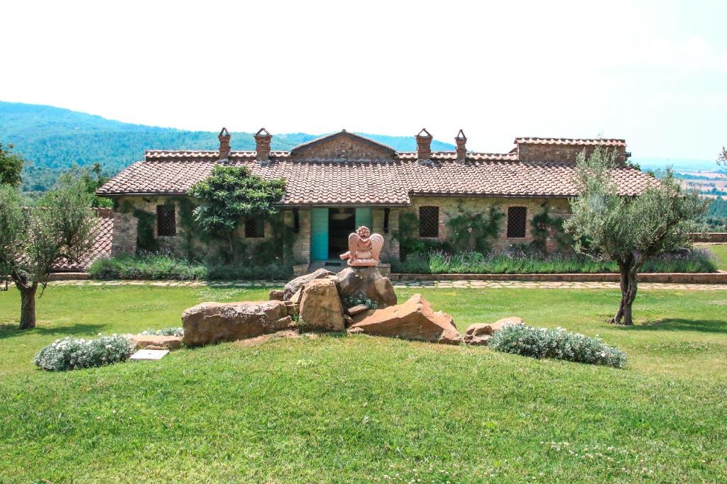 ピエガーロにあるResort Podere dell'Angioloの家の前の岩に座った像