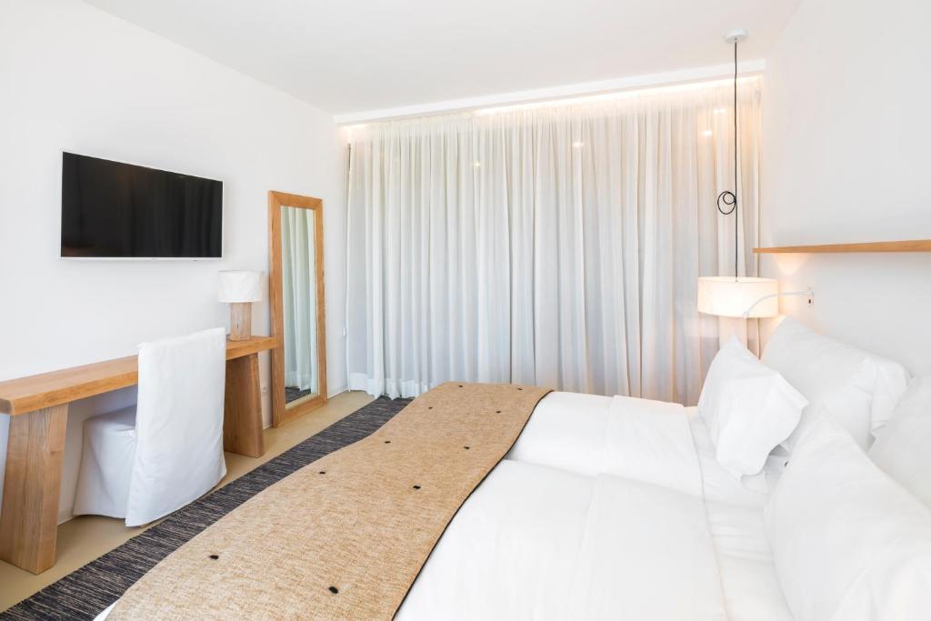 a hotel room with a white bed and a television at Lagos Avenida Hotel in Lagos