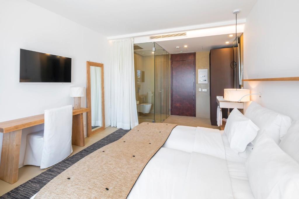 a hotel room with a white bed and a television at Lagos Avenida Hotel in Lagos