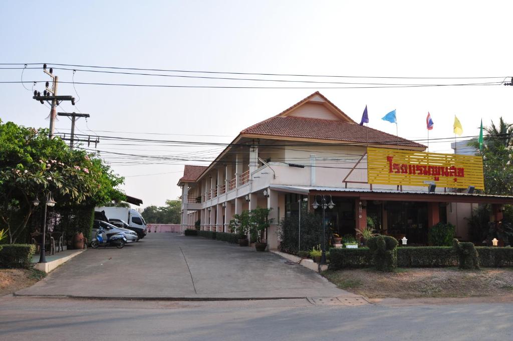 um edifício com um restaurante ao lado de uma rua em Poon Suk Hotel Kabin Buri em Kabin Buri