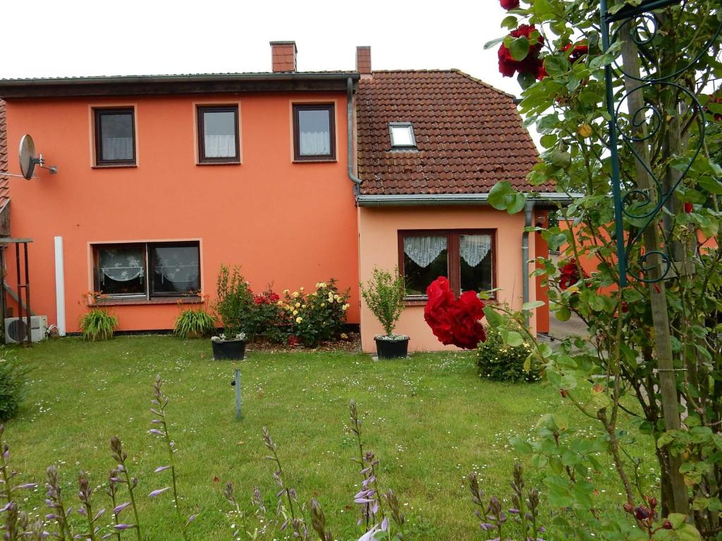 トレントにあるFeWo WE 6402 Ferien u Angeln auf Rügen-ruhige Lage,Garten!の植物園のあるオレンジハウス