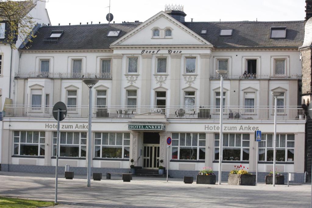 Un grand bâtiment blanc avec de nombreuses fenêtres dans l'établissement Hotel zum Anker, à Andernach