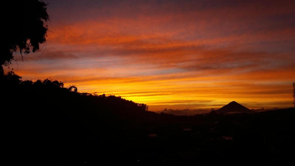 einen Sonnenuntergang mit einem Berg im Hintergrund in der Unterkunft Bajawa-Roo Hotel in Bajawa
