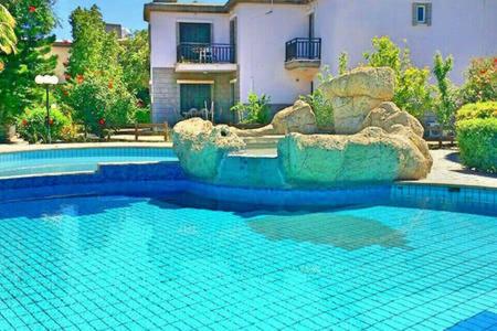 a swimming pool in front of a house at Larnaka Beach House 3 in Larnaca