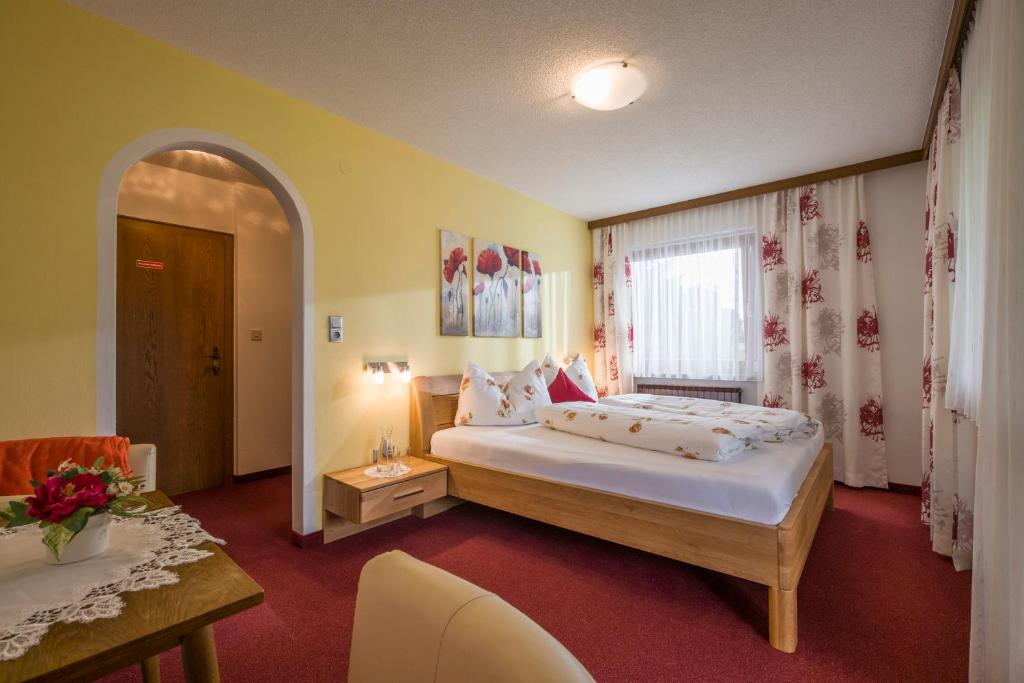 ein Hotelzimmer mit einem Bett und einem Tisch in der Unterkunft Gästehaus Gisela in Bruck am Ziller