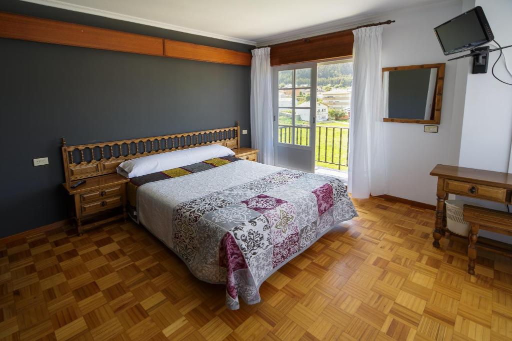 1 dormitorio con 1 cama, TV y ventana en As Areas II, en Viveiro