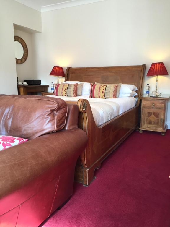 a bed with a leather couch in a room at Sandpiper House in Whitby