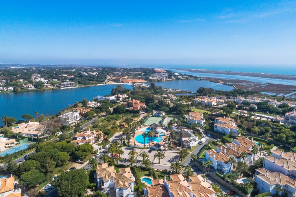 eine Luftansicht eines Resorts neben einem Wasserkörper in der Unterkunft Encosta Do Lago Resort Club in Quinta do Lago