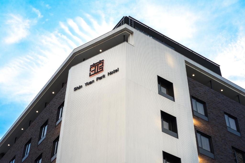 a building with a sign on the side of it at Shin Yuan Park Hotel in Hsinchu City