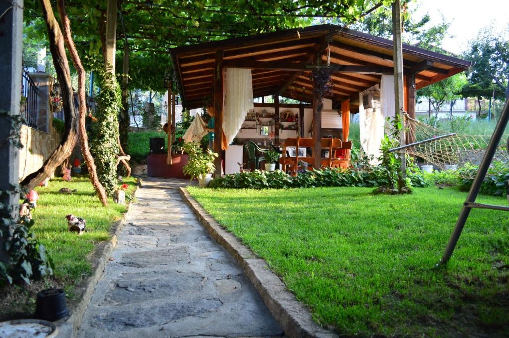 un jardín con un pabellón de madera en el césped en Guest House Angelkovi en Sapareva Banya