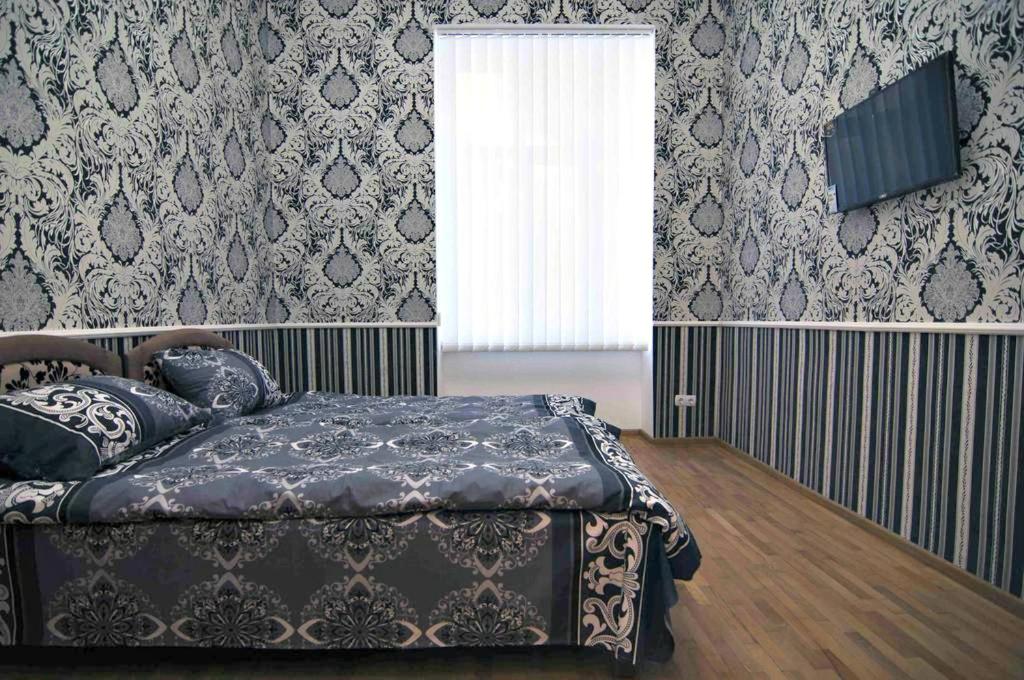 um quarto com uma cama e uma televisão na parede em Green Street Hostel em Lviv