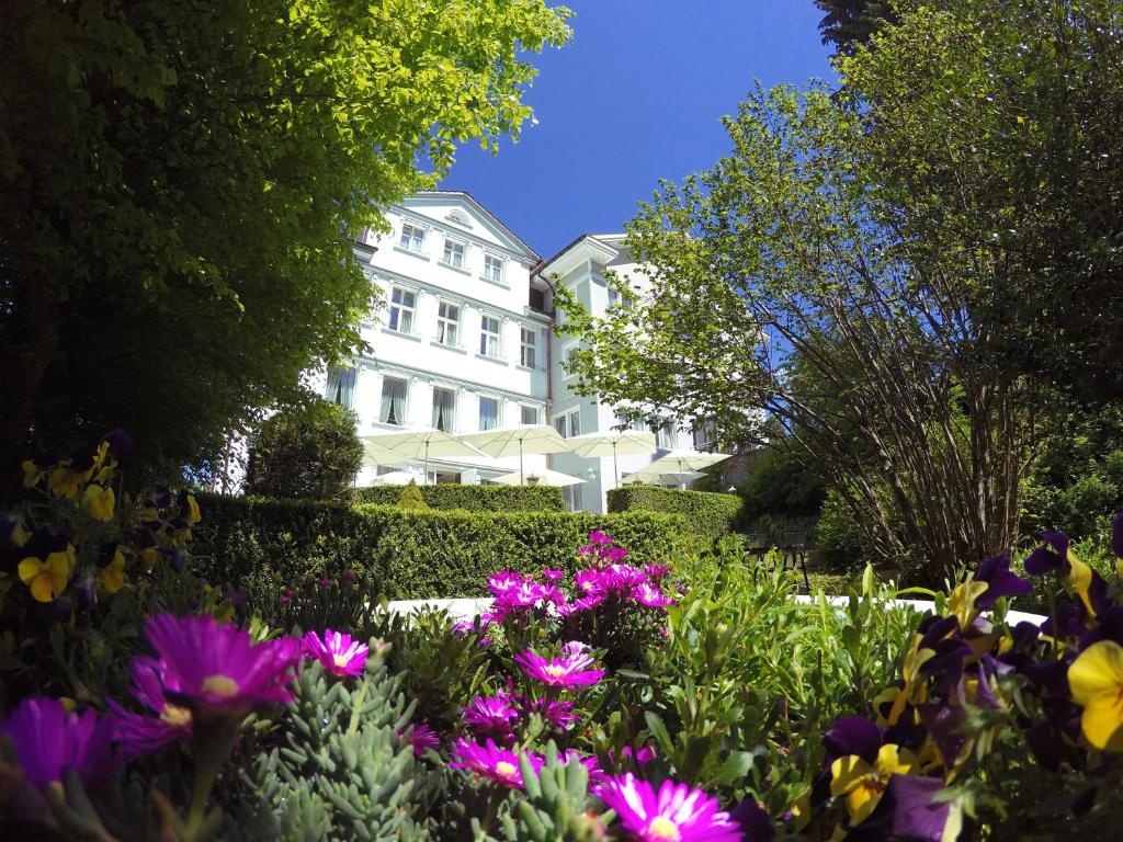 Un bâtiment blanc avec des fleurs devant lui dans l'établissement Hotel & Spezialitätenrestaurant zur Linde, à Teufen