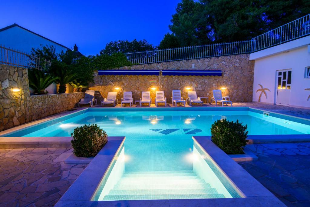 a swimming pool in a backyard at night at B&B Villa Paula in Trogir