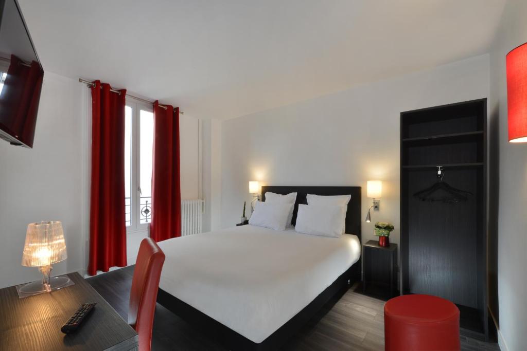 a bedroom with a white bed and red curtains at Hotel Douglas in Puteaux