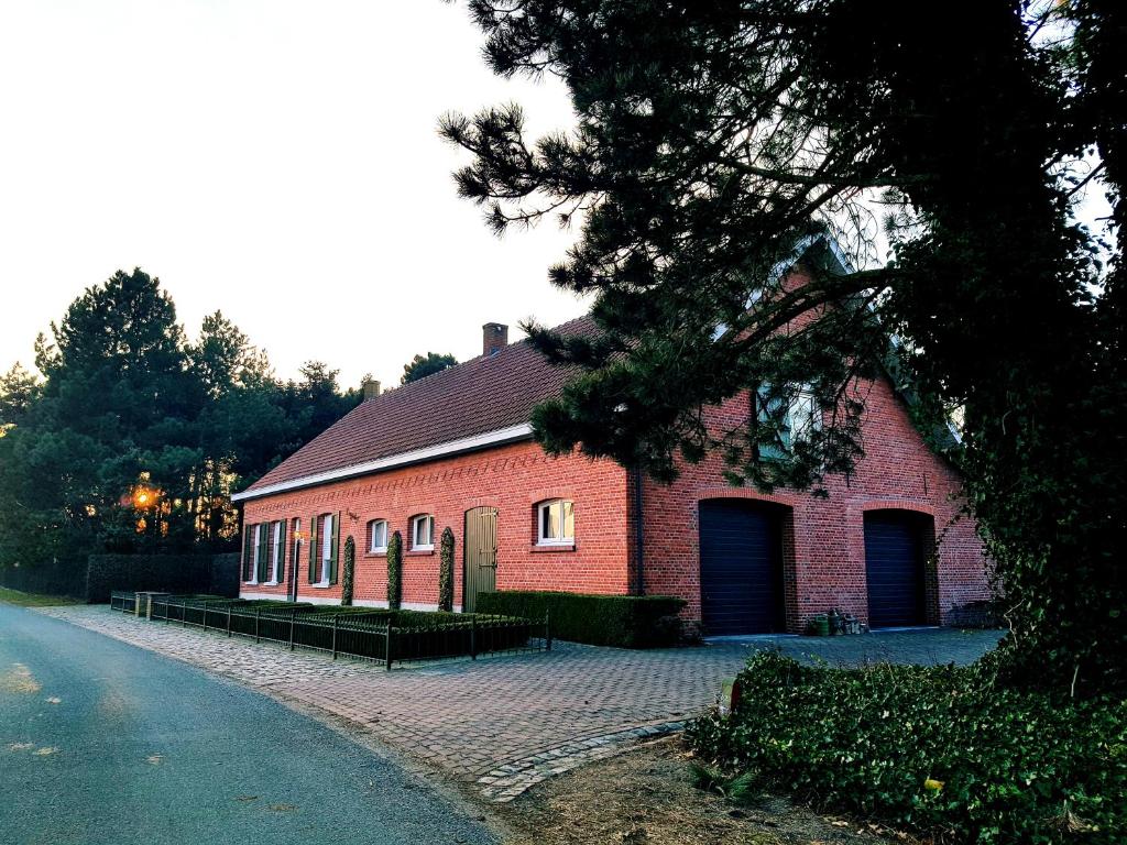 um edifício de tijolos vermelhos com duas portas de garagem numa rua em B&B Bergenhof em Hoogstraten