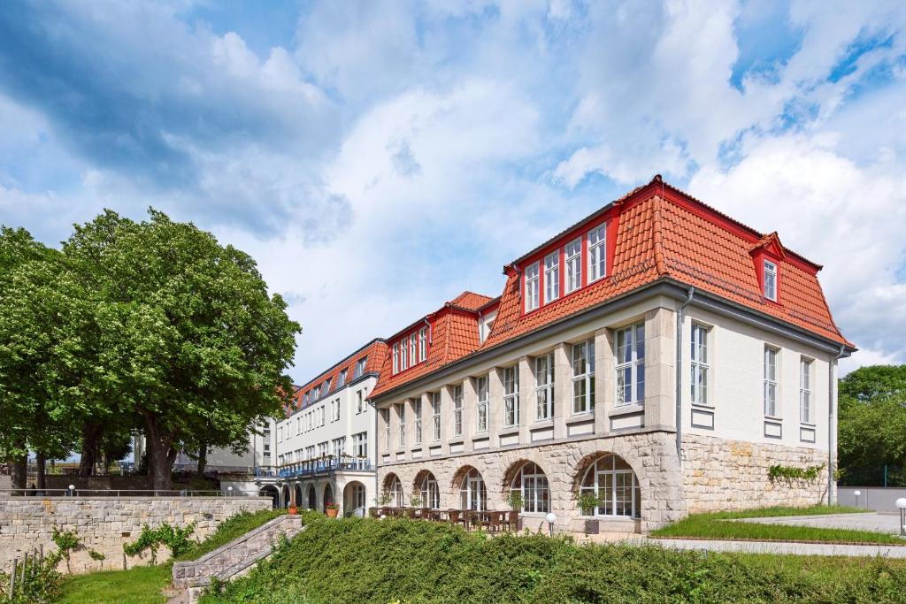 un grand bâtiment en briques avec un toit rouge dans l'établissement Weinberghotel Edelacker, à Freyburg