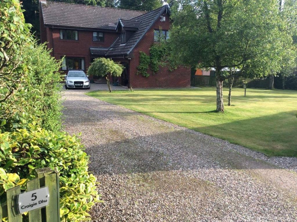una casa con un coche aparcado frente a una entrada en Craigie dhu, golf haven en Colliston