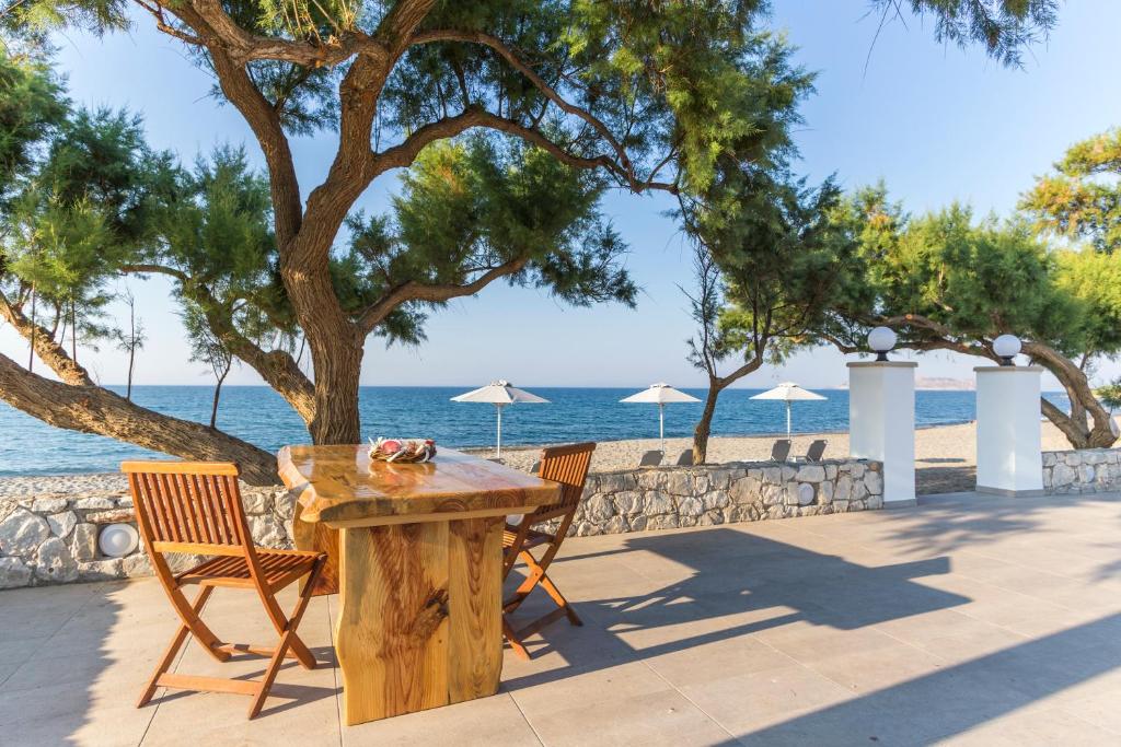 a wooden table and chairs next to the beach at Electra Studios in Gerani Chanion