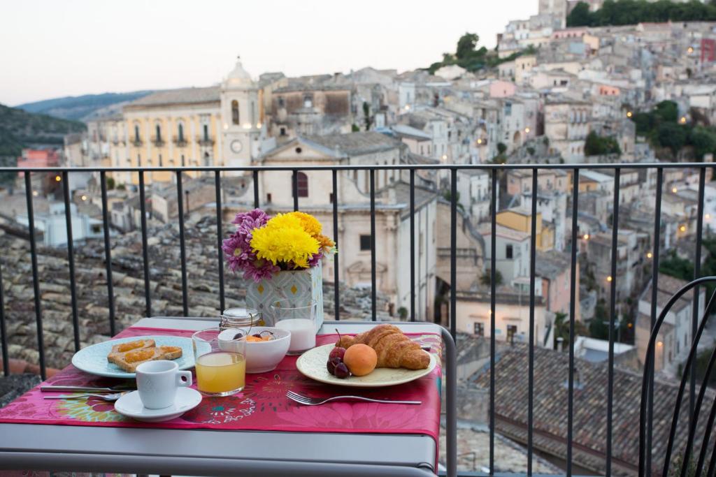 a table with plates of food and a view of a city at Intervallo Boutique Hotel in Ragusa