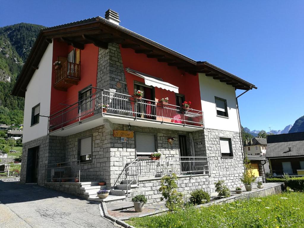 Edificio rojo y blanco con balcón en Casa Il Glicine, en Baceno