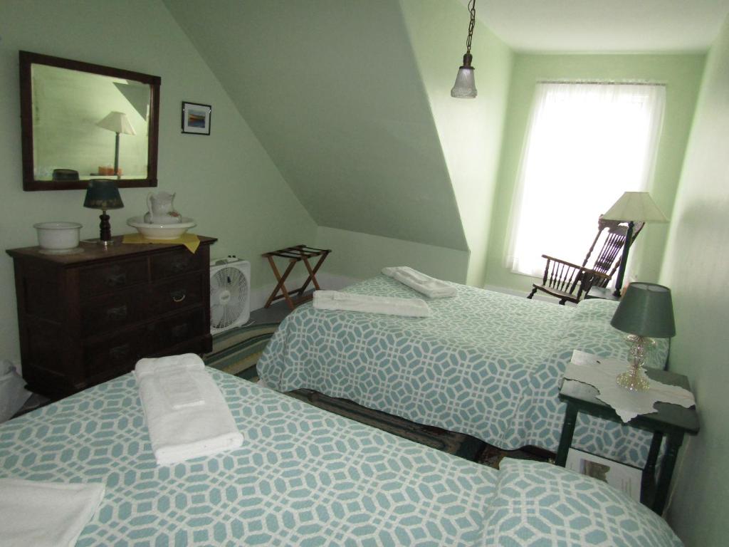 a bedroom with two beds and a mirror at The 8th Maine Regiment Lodge and Museum in Peaks Island