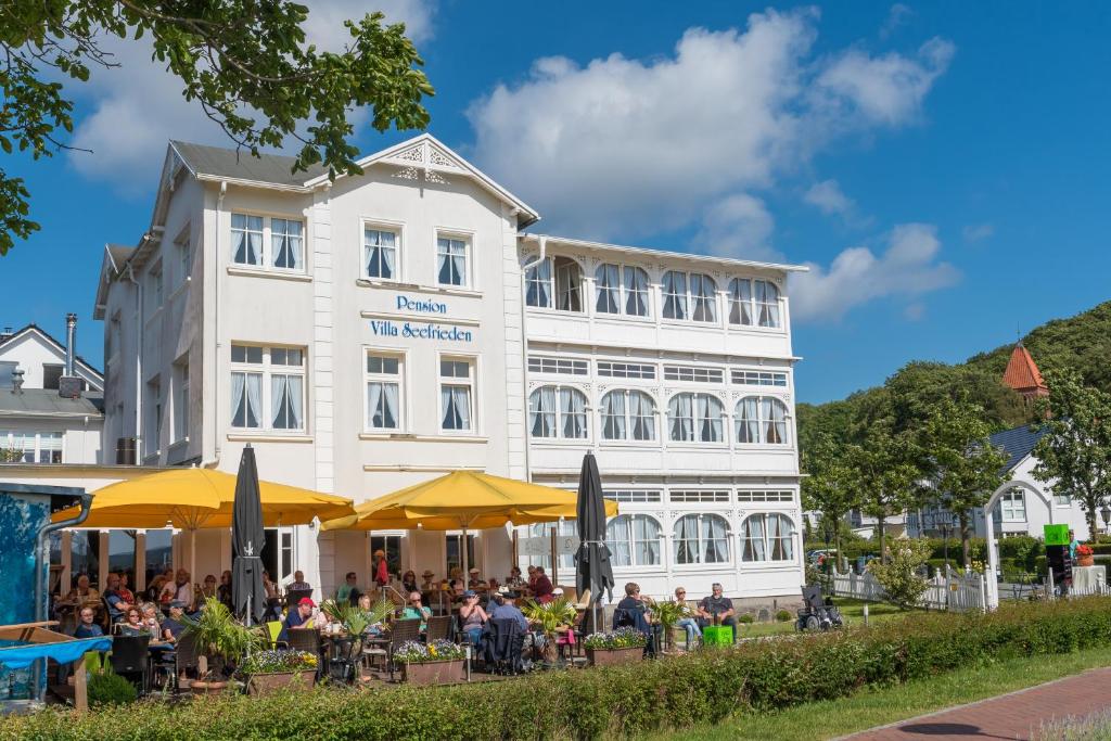 un grupo de personas sentadas fuera de un edificio en Pension Villa Seefrieden, en Binz