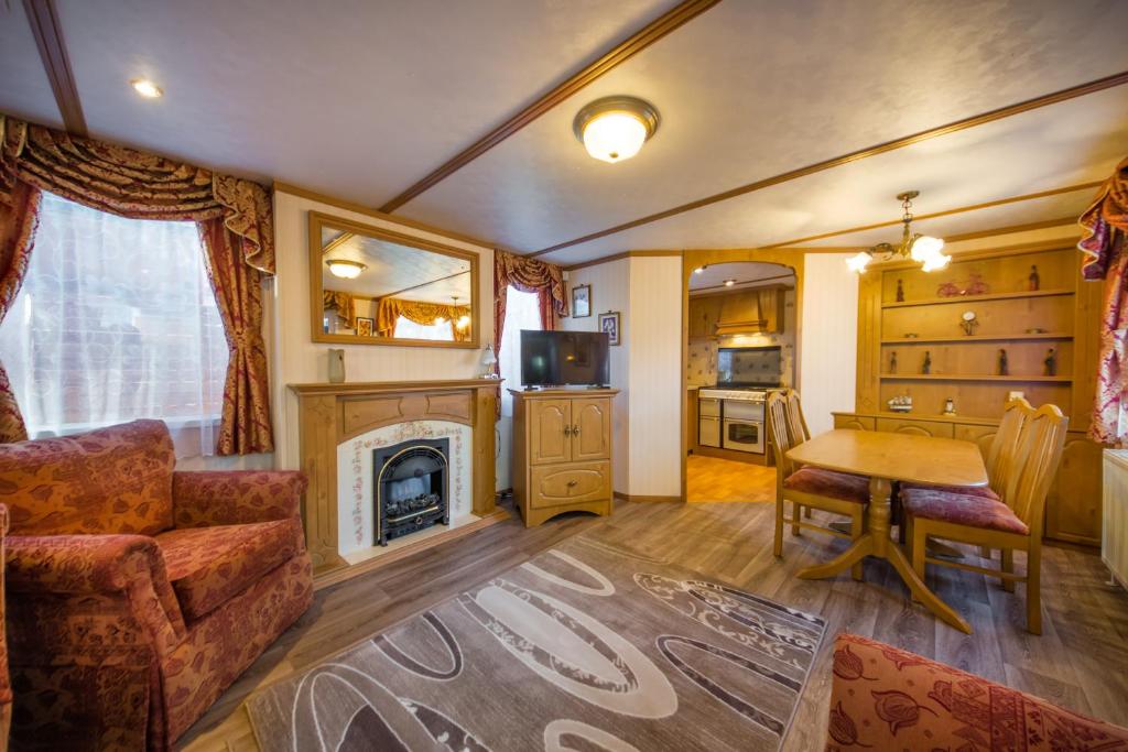 a living room with a table and a fireplace at Domek Promyk in Jurata