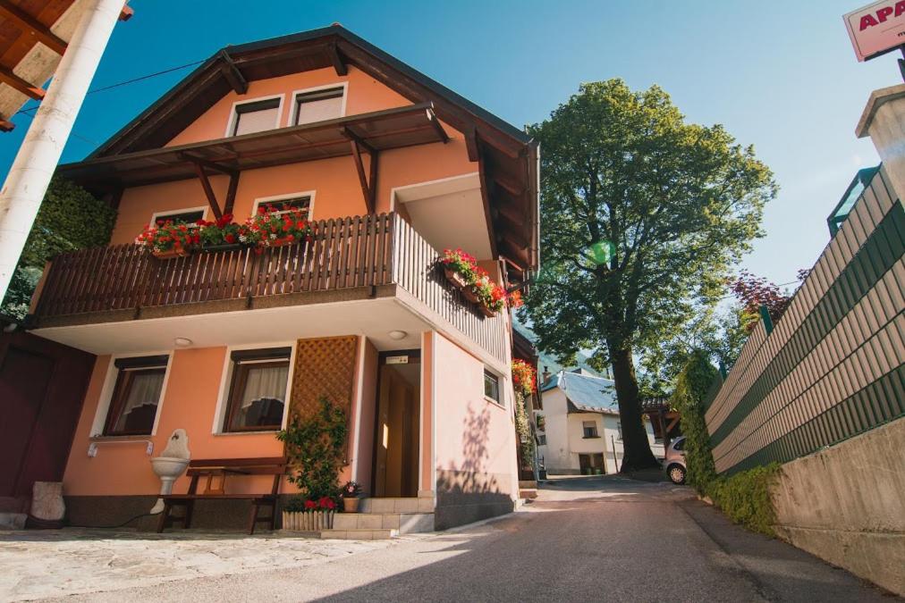 ein Haus mit Blumen auf den Balkonen auf einer Straße in der Unterkunft Apartment & Rooms Bruna Vučič in Bovec