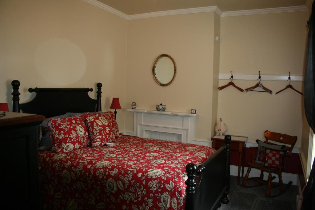 a bedroom with a bed with a red blanket at The 1819 Red Brick Inn in Dundee