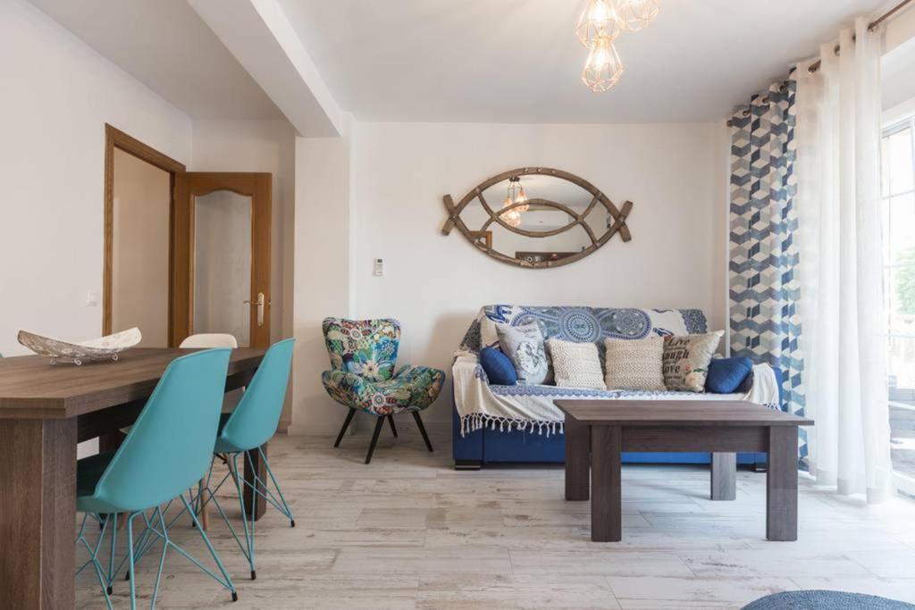 バレンシアにあるLaura Sea View Apartmentのリビングルーム(ソファ、テーブル、椅子付)