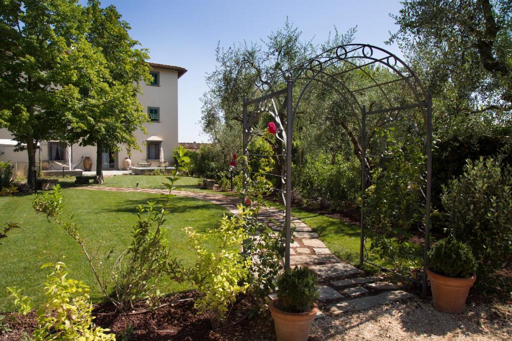 einen Garten mit einer Laube und einigen Pflanzen in der Unterkunft Roveta Apartment in Scandicci