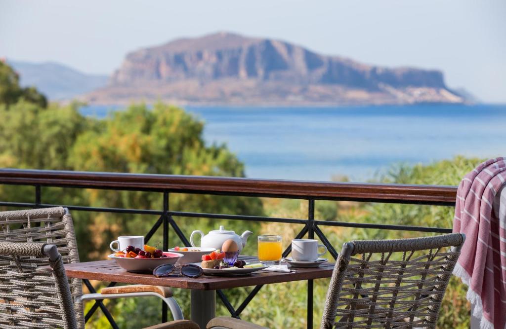 een tafel met eten en drinken op het balkon bij Iris Beach Hotel in Monemvasia