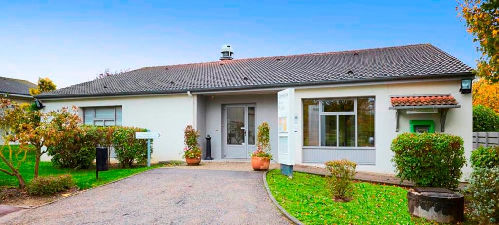 a white house with a driveway in front of it at Campanile Thionville - Yutz in Basse-Yutz