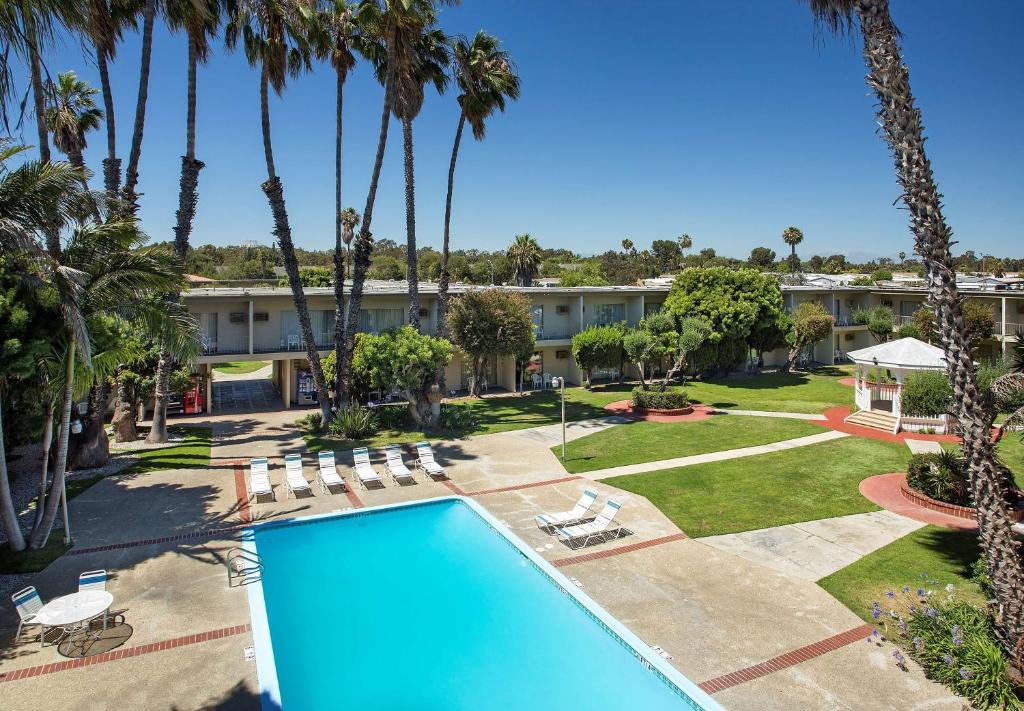 uma vista aérea do resort com uma piscina e palmeiras em Golden Sails Hotel em Long Beach