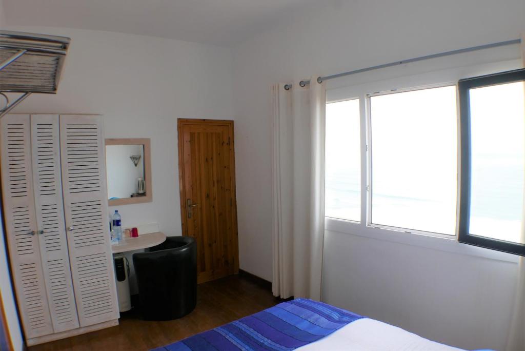 a bedroom with a bed and a large window at logis la marine in Sidi Ifni