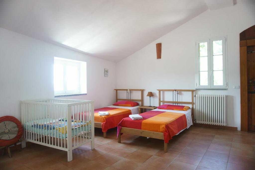 a bedroom with two beds and a crib at Farmhouse B&B Castagnola 64 in Ne