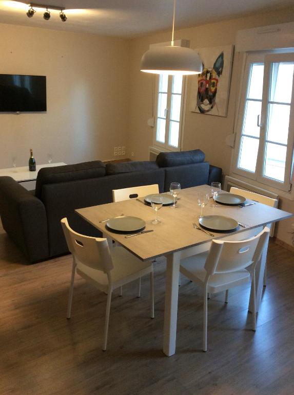 uma sala de estar com uma mesa com cadeiras e um sofá em montreuil sur mer em Montreuil-sur-Mer