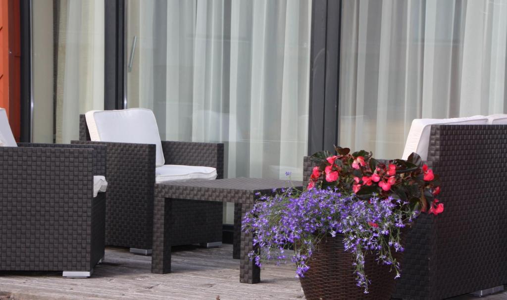 a patio with chairs and a table with flowers in a vase at Family friendly Apartment Baltic Seaside in Šventoji