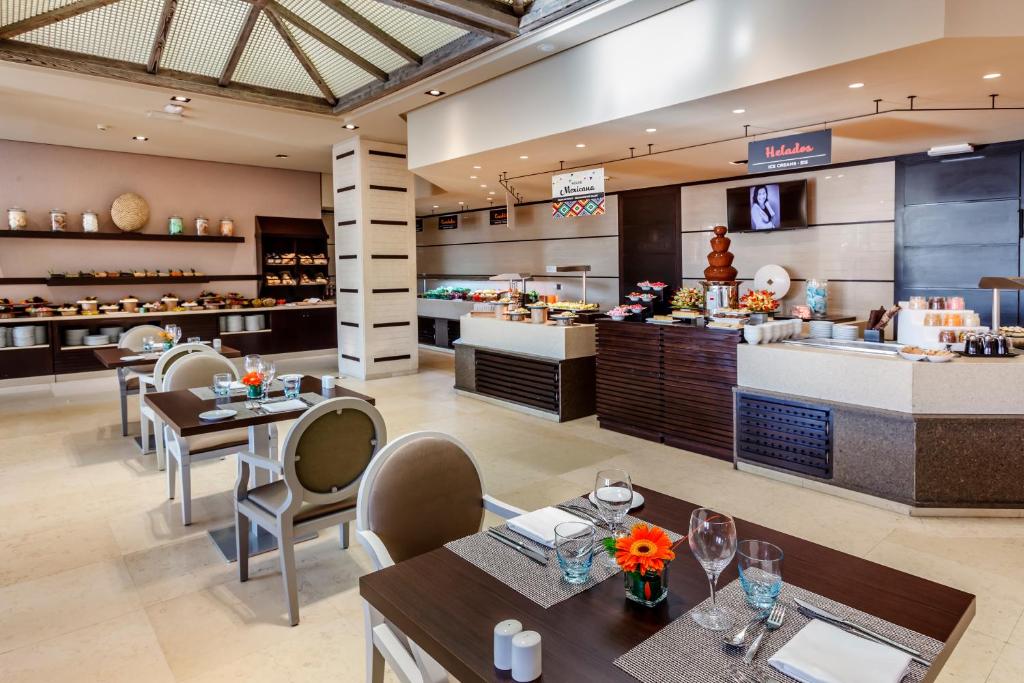 a restaurant with tables and chairs and a counter at Royal Hideaway Sancti Petri in Chiclana de la Frontera