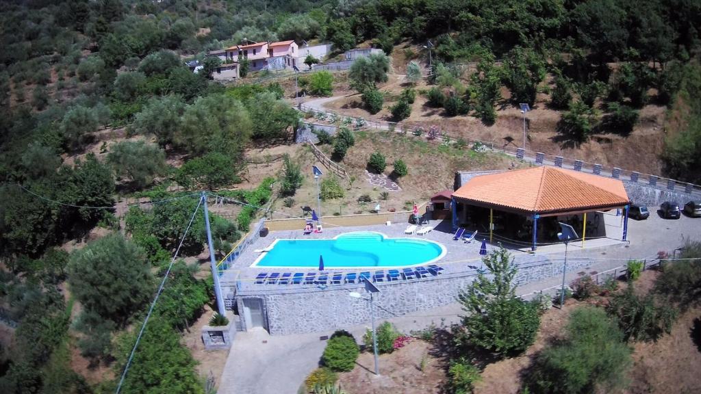een uitzicht op een zwembad met een prieel bij Agriturismo Il Sole in SantʼAngelo di Brolo