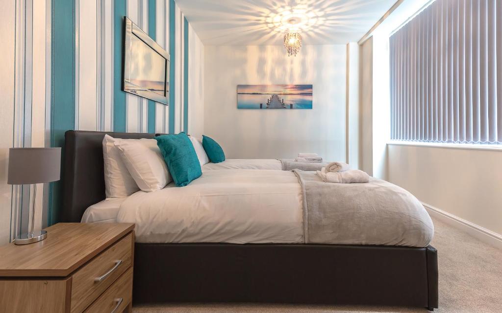 a bedroom with a large bed and a window at Comfortable Swindon Town Centre Apartments, FREE Parking, sleeps up to 6 in Swindon