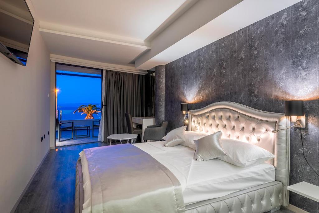 a bedroom with a large bed and a balcony at Luxury rooms ''Seven'' in Split