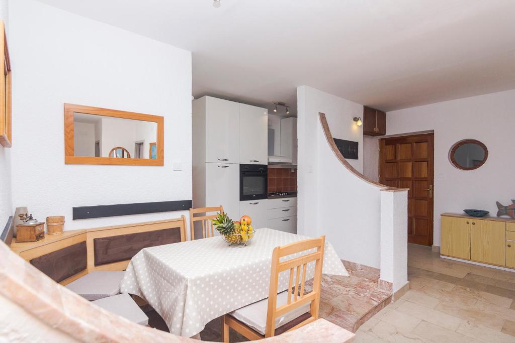 eine Küche und ein Esszimmer mit einem Tisch und Stühlen in der Unterkunft APARTMENTS A&B in Makarska