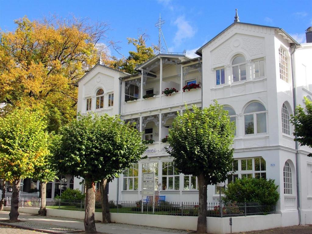 a white house with trees in front of it at Ferienappartement-Moenchgut-01 in Ostseebad Sellin