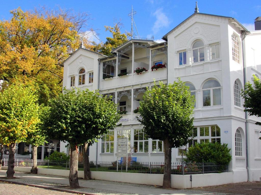 a white house with trees in front of it at Ferienappartement-Moenchgut-21 in Ostseebad Sellin