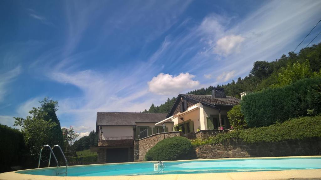 une maison avec une piscine en face d'une maison dans l'établissement B&B Le Nid Doux (Vresse-Sur-Semois/Chairière), à Vresse-sur-Semois