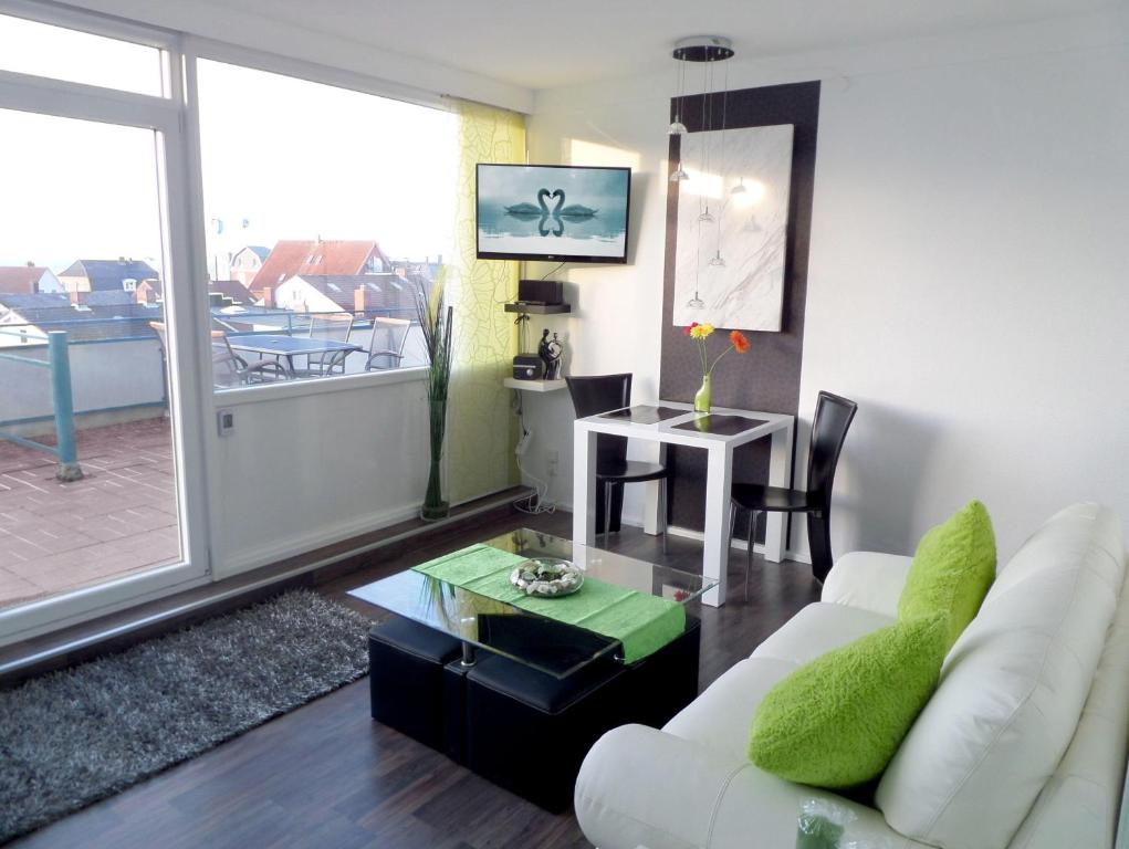 a living room with a white couch and a table at Ferienwohnung-Kassiopeia in Laboe