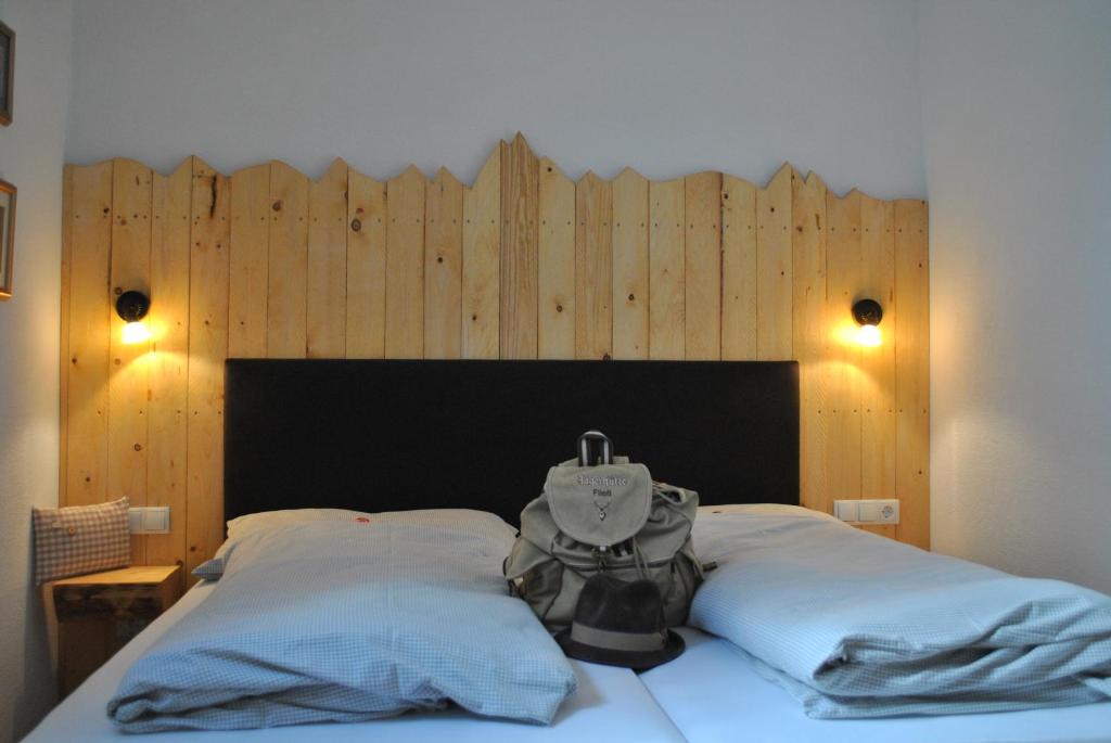 um quarto com uma cama e uma parede de madeira em Chasa Chalur em Fliess
