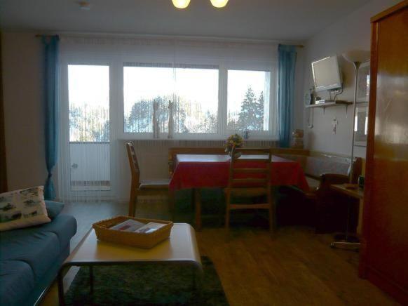 uma sala de estar com uma mesa e uma sala de estar com um sofá azul em Falkenhorst-Wohnung-40 em Oberstdorf